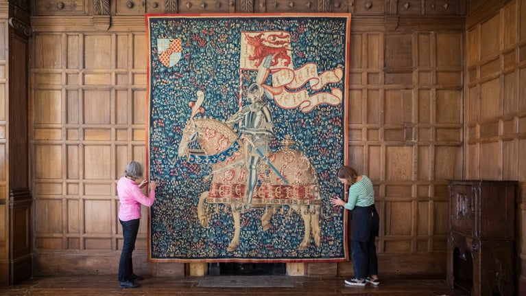 Two Conservators rehanging Knight with the Arms of Jean de Daillon by Guillaume Desremaulx at Montacute, Somerset